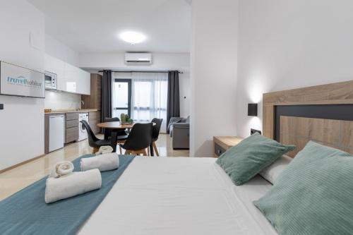 瓦伦西亚Travel Habitat La Marina Real的一间带白色大床的卧室和一间厨房