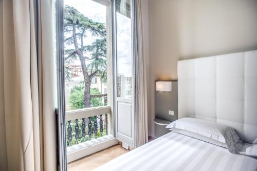 佛罗伦萨阿尔乐酒店的一间卧室设有一张床和一个大窗户