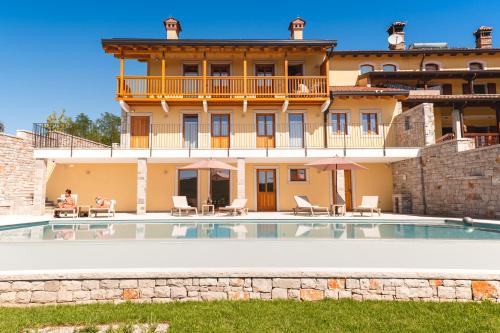 Doberdò del Lago帕霍尔餐厅酒店的一座别墅,在一座建筑前设有一个游泳池
