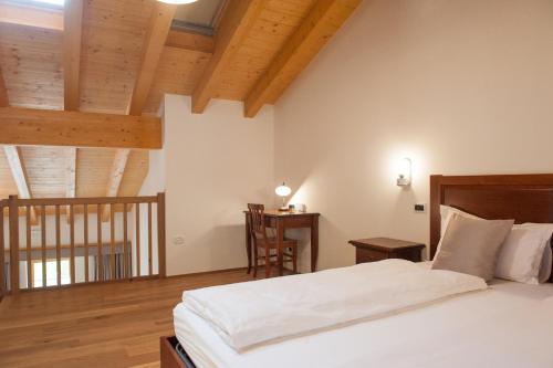 Doberdò del Lago帕霍尔餐厅酒店的卧室设有白色大床和木制天花板。
