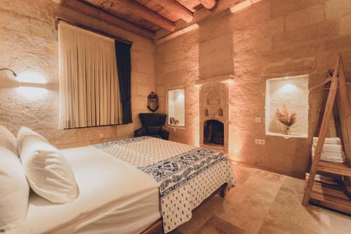 乌奇希萨尔La maison de Şişik的一间卧室配有一张床和一个壁炉