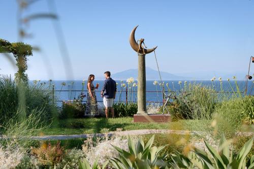 卡普里卡普里滨海别墅酒店的站在鸟雕像旁的男女