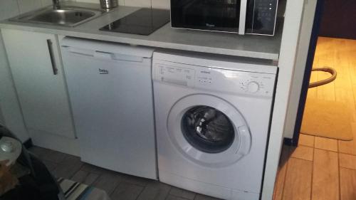 康博莱班甘德圭亚公寓的厨房里的白色洗衣机,旁边是水槽
