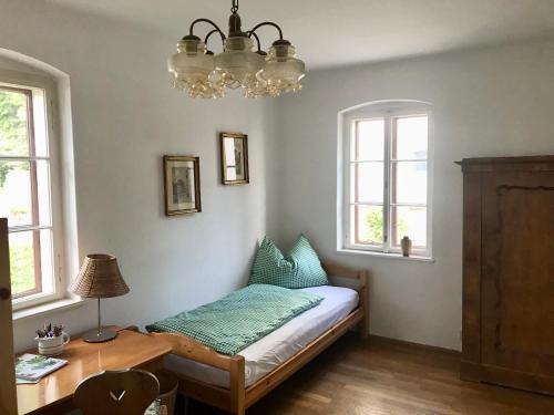 格蒙登Haus Traundorf的卧室配有床、桌子和窗户。