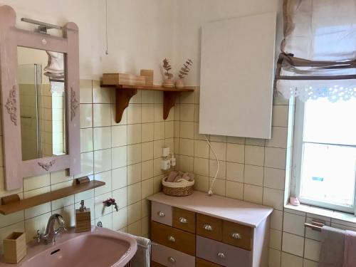 格蒙登Haus Traundorf的浴室设有粉红色的盥洗盆和镜子