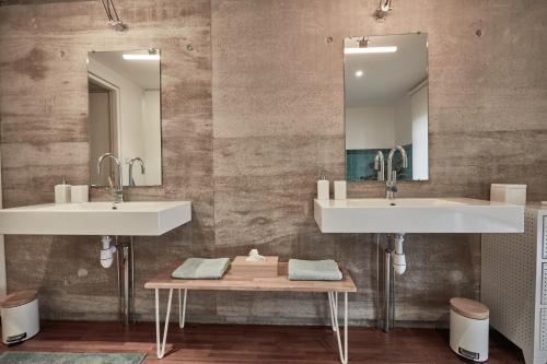 鲁贝LA PORTE ROUGE RBX的一间带两个盥洗盆和木桌的浴室