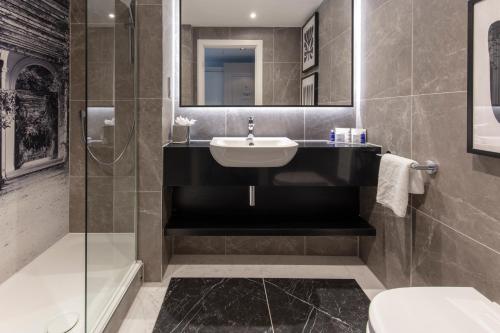 利兹Oulton Hall Hotel, Spa & Golf Resort的一间带水槽、淋浴和卫生间的浴室