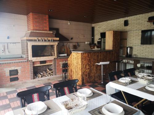 阿拉木图Гостевой дом Discovery的厨房设有砖砌壁炉、桌子和椅子