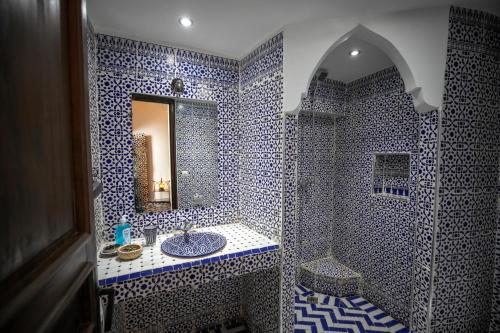 非斯达尔哈芙赛旅馆的蓝色和白色的浴室设有水槽和镜子