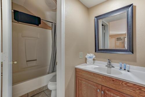 BurneyShasta Pines Motel & Suites的一间带水槽、卫生间和镜子的浴室