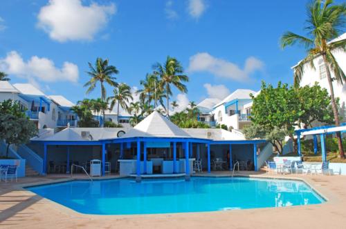 Creek VillagePerfect Island Retreat at Paradise Island Beach Club Villas的一个带大型游泳池和棕榈树的度假村
