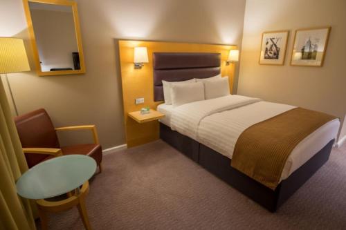 布伦特福德假日伦敦布伦特福德湖酒店的小型酒店客房配有一张床和一张桌子