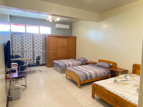 Changhua County彰濱伸港民宿的客房设有两张床、一张桌子和一张桌子。