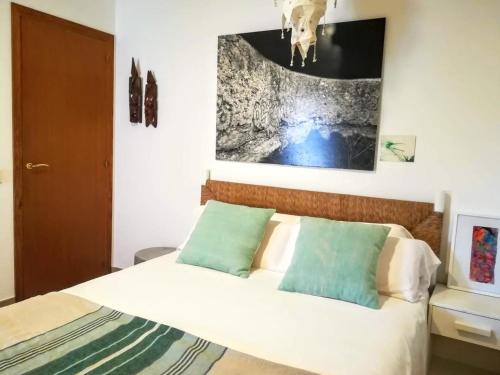 圣弗朗西斯科哈维尔Ca n'Antonia Formentera的卧室配有一张床,墙上挂有绘画作品