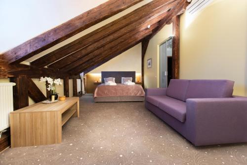 塔林Bern Boutique Hotel的一间卧室配有一张紫色的沙发和一张床