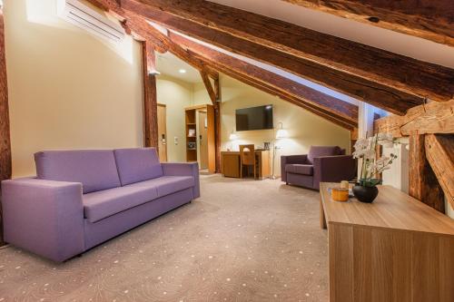 塔林Bern Boutique Hotel的客厅配有紫色沙发和电视