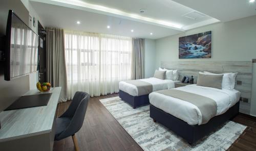 内罗毕Hotel Mokka City的酒店客房设有两张床和电视。