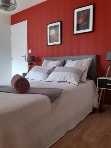 布吕兹Kerlann Bruz的卧室设有红色的墙壁和一张带白色枕头的床