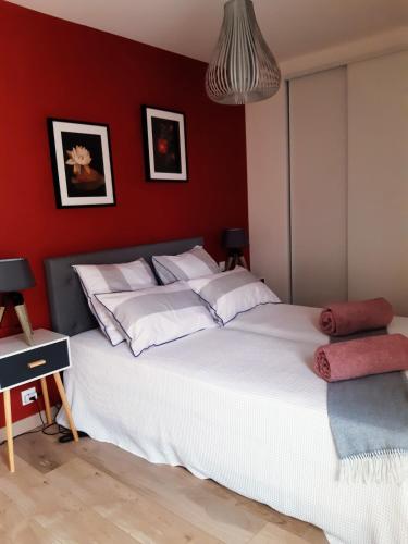 布吕兹Kerlann Bruz的卧室配有白色的床铺和红色的墙壁