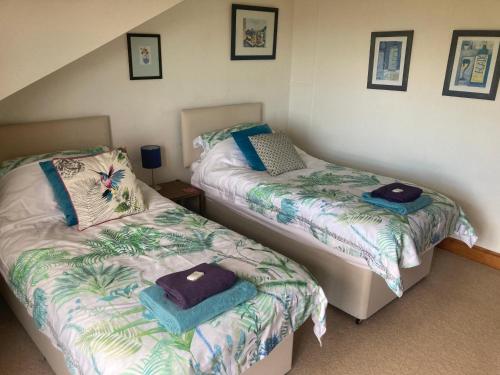 爱丁堡Midkinleith Farm Holiday Cottage的一间卧室配有两张带毛巾的床