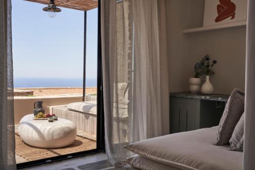 提诺斯Under the Sun Cycladic Village的一间卧室,从镜子上可欣赏到海滩景色