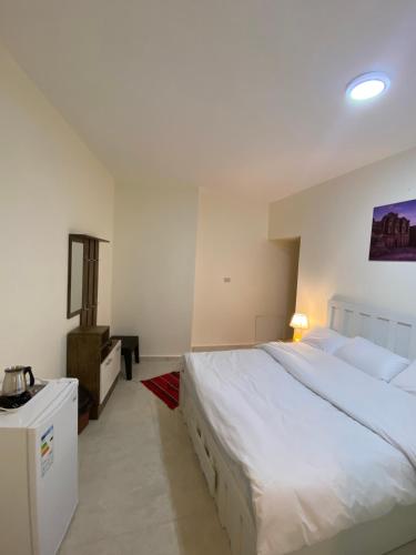 瓦迪穆萨Rose city inn的卧室配有白色大床和梳妆台