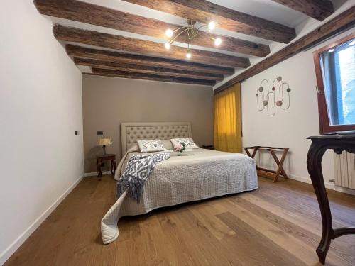 威尼斯Ca' ai Sospiri的一间卧室设有一张床和木制天花板