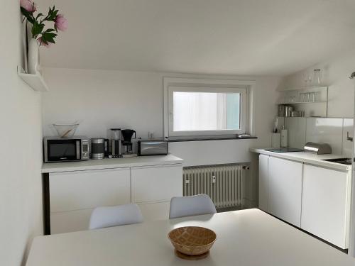 弗罗伊登施塔特City Flat gegenüber Kurhaus, Zentrum Freudenstadt的白色的厨房配有桌子和两把椅子