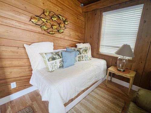 维洛海滩Comfy Beach House on Vero Beach的一间卧室配有一张带木墙和窗户的床。