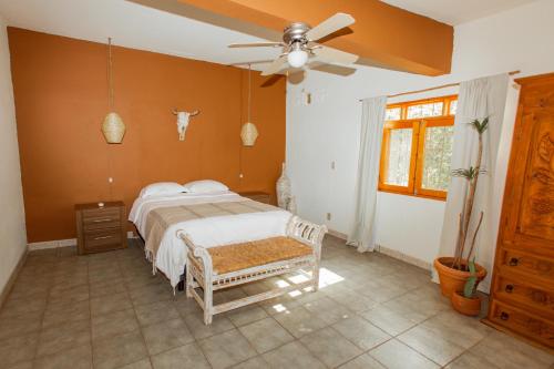 托多斯桑托斯Cien Palmas- Authentic Mexican Casita 1 -Downtown的一间卧室配有一张床和吊扇