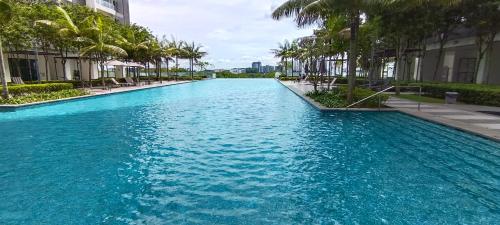 塞贝维Cyberjaya cybersqure peace home的棕榈树和建筑的蓝色海水游泳池
