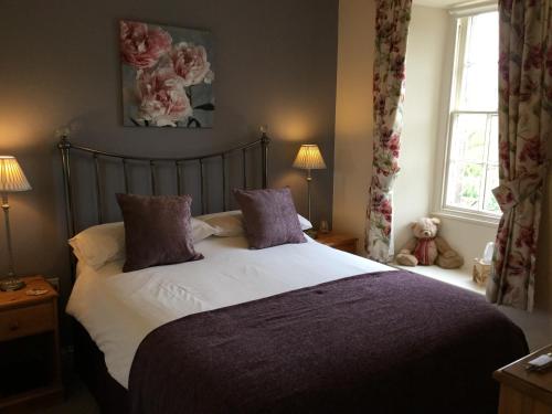 斯基普顿Crown Cottage Farm的一间卧室配有一张带紫色枕头的床和窗户。