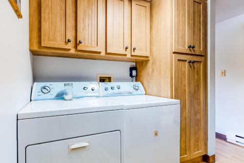 莱克哈莫尼Harmony Haven的带木制橱柜的厨房内的洗衣机和烘干机