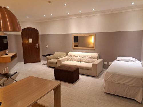 桑托斯普拉亚弗莱特四海之家酒店的酒店客房设有床和客厅。