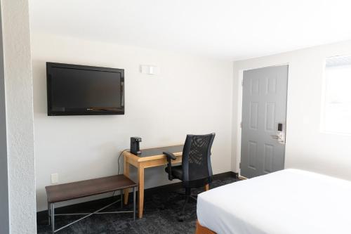 WorlandEcono Inn的酒店客房设有一张桌子和一台墙上的电视
