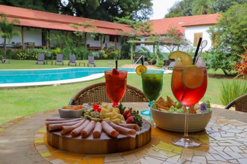 多拉杜Hotel Fazenda Bela Vista的一张桌子,上面放着一盘食物和两杯饮料