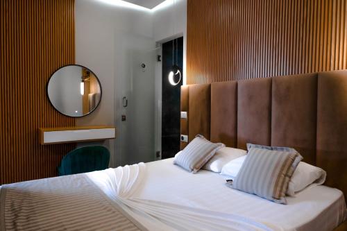 博尔什Luna Mare Seaside Suites的一间卧室配有一张大床和大镜子