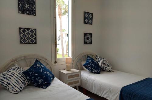 桑帕克Apartamento Son Parc Menorca的两张带蓝色和白色枕头的床