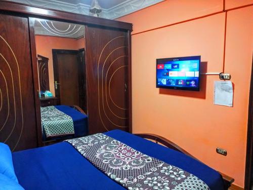 亚历山大Fayrouzat Smoha near the city with open view的卧室配有一张床,墙上配有电视。