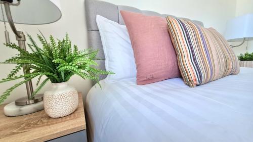 谢菲尔德City Centre 2 Bedroomed Apartment - Great views - wifi的一张带枕头的床和一个花瓶