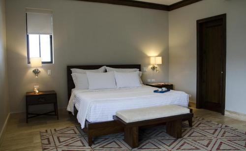 埃尔巴列德安通Paseo Suites El Valle, Luxury Apartments的卧室配有一张白色的大床和两张桌子