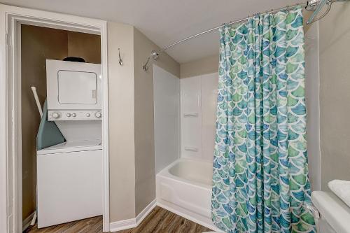 帕德雷岛Leeward Isles 207的浴室配有淋浴帘和浴缸。