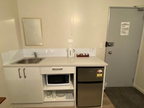 奥克兰Airport Westney Lodge的一间带水槽和微波炉的小厨房