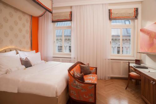 维也纳凯瑟霍夫温酒店的酒店客房设有一张床、一张书桌和窗户。