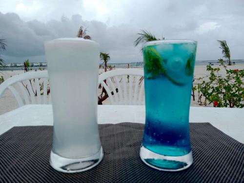 古雷德胡La Isla Tropica的坐在桌子上,坐在沙滩上,两杯饮酒