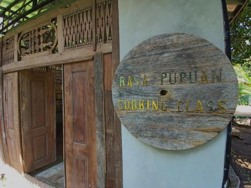 塔巴南Bali Jungle Camping by Amerta Experience的建筑物一侧有门的标志