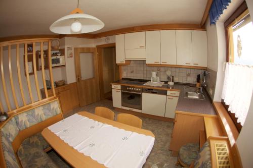 ReisachHaus Stöffler的小厨房配有白色橱柜和桌子