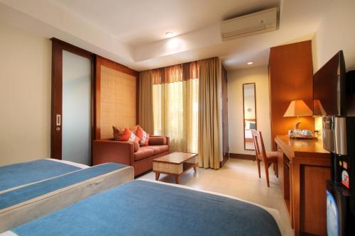 勒吉安巴厘岛拉玛花园酒店的配有一张床和一张书桌的酒店客房