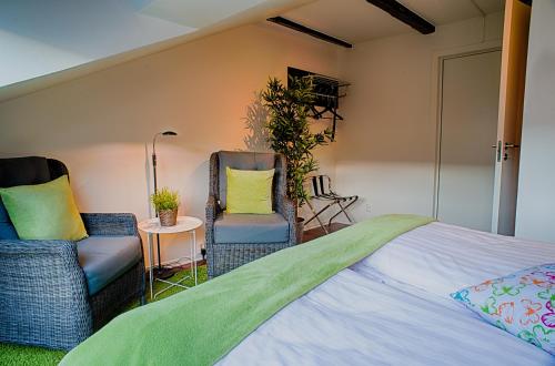 赫尔辛堡H5酒店的一间卧室配有两把椅子和一张床