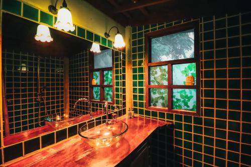 卡农里罗天堂酒店的绿色瓷砖浴室设有两个水槽和两个窗户